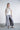 Flow wide-leg pants displayed on a plain background, featuring a cropped length, elastic drawstring waist, and clean welt-style side pockets with a fluid, lightweight drape